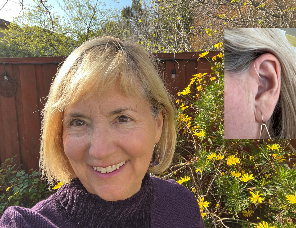 Meri showing the tiny hearing aid in her ear